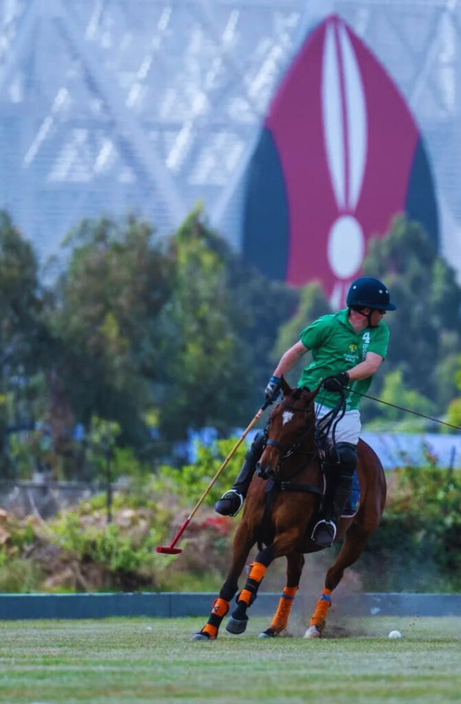 IDENTITY – A gent plays polo with the Talanta Stadium in the background. Polo has drawn exclusive crowds and offers entertainment, community, and lifestyle for fans and players.